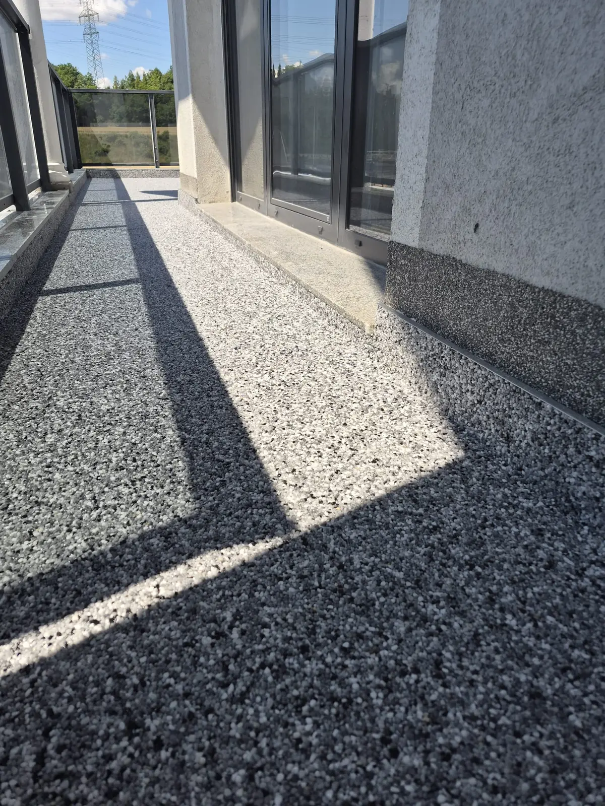 Fertig verlegter grauer Natursteinteppich auf einem Balkon